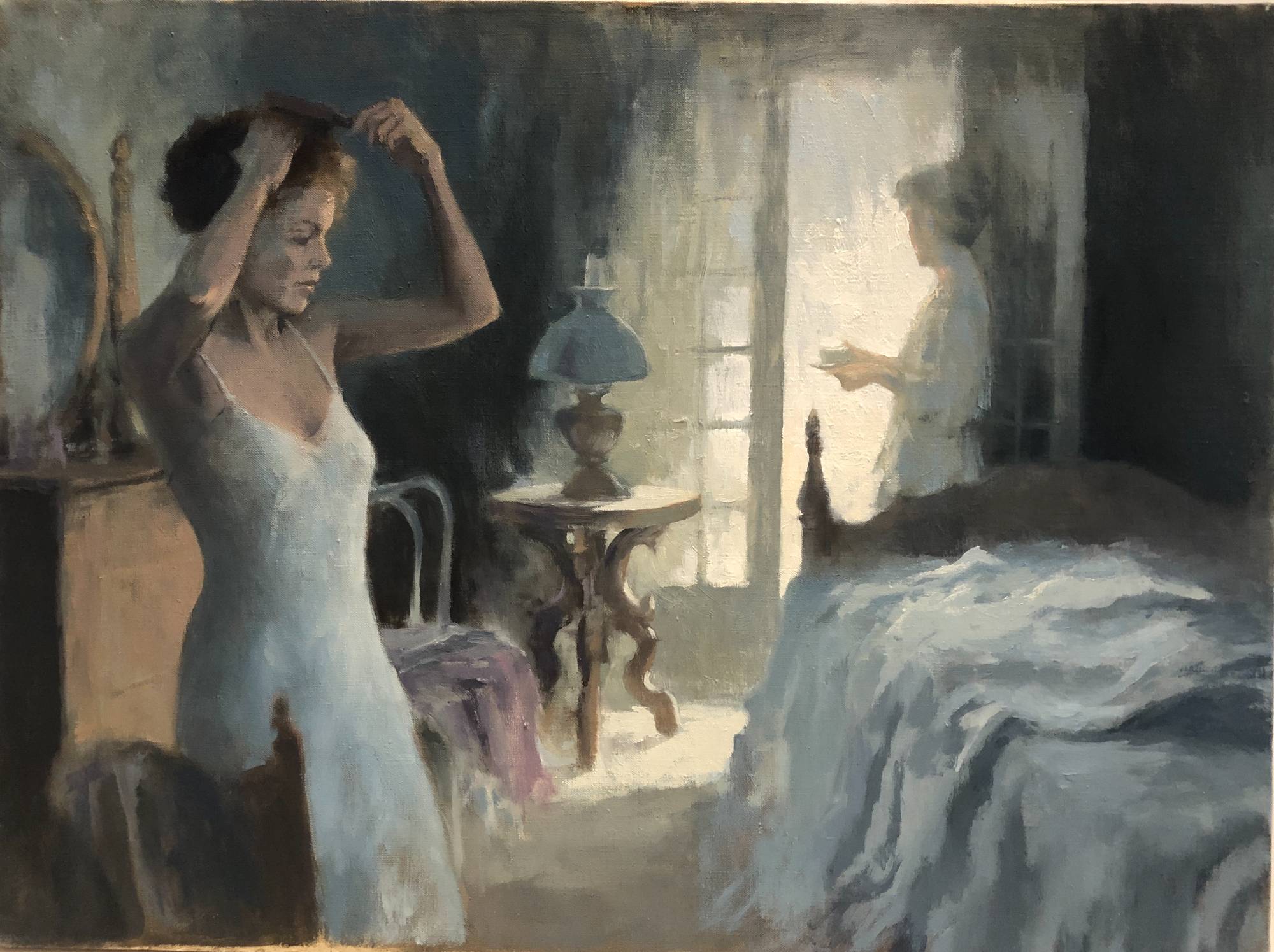 woman in slip fixing her hair in a bedroom